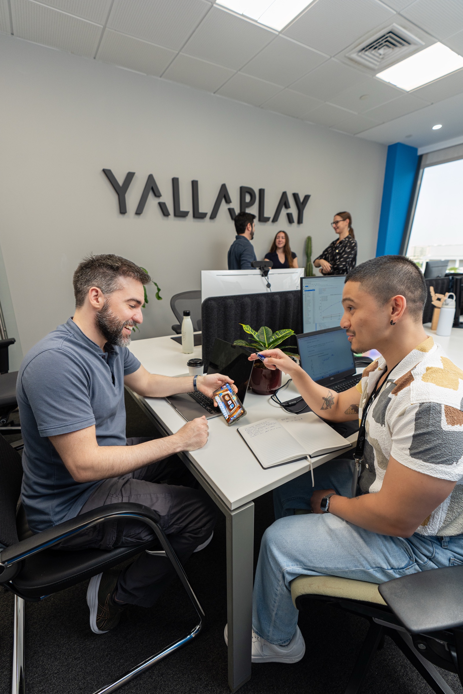 YallaPlay teammates discussing a game together in the office